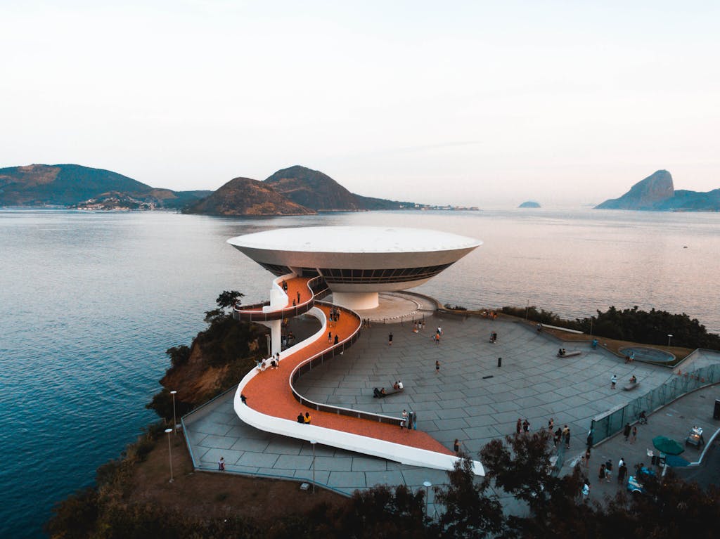 A breathtaking aerial view of the Niterói Contemporary Art Museum in Brazil, surrounded by sea and mountains.