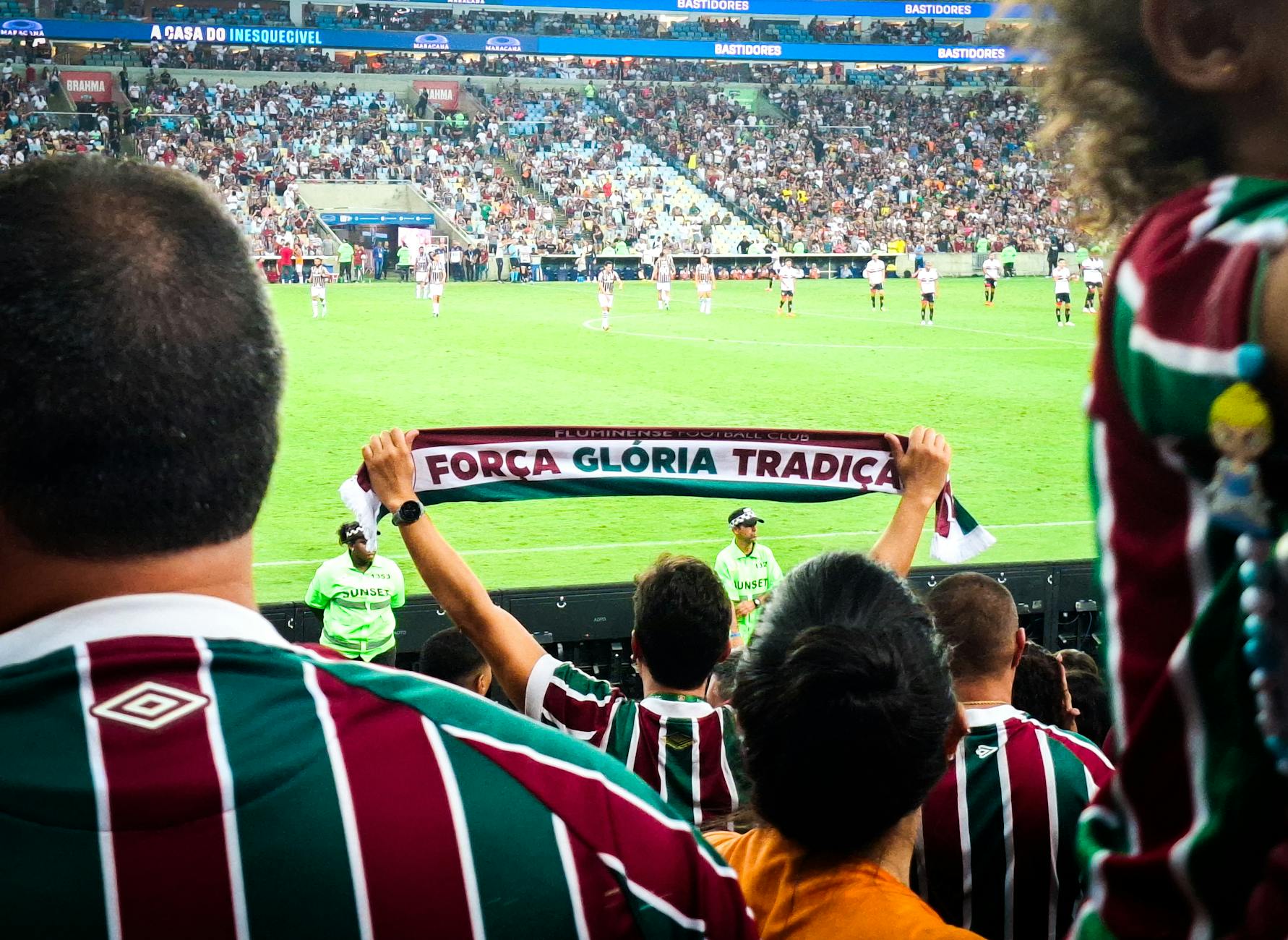 Cheering crowd at Maracanã Stadium supporting Fluminense FC during an intense football match.