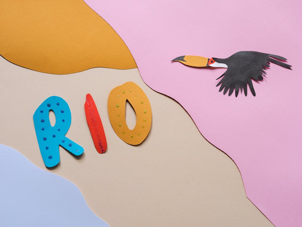 Vibrant paper art of the word 'Rio' with a toucan, evoking Brazilian carnival vibes.